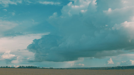 A Dynamic and Colorful Cloudscape Over Expansive Rolling Fields During Dusk and Twilightの写真素材