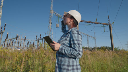 A dedicated worker dressed in protective gear is diligently monitoring an electrical substation