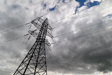 A Power Transmission Tower Stands Tall Against The Backdrop Of A Dramatic Sky Aboveの写真素材