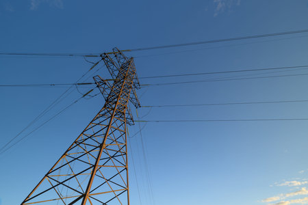 Power Lines Standing Tall Against a Beautiful Clear Sky with Light Clouds