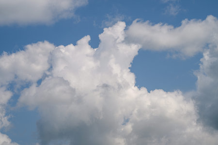 There are Fluffy White Clouds in a Beautiful Blue Sky, creating a peaceful and tranquil scene