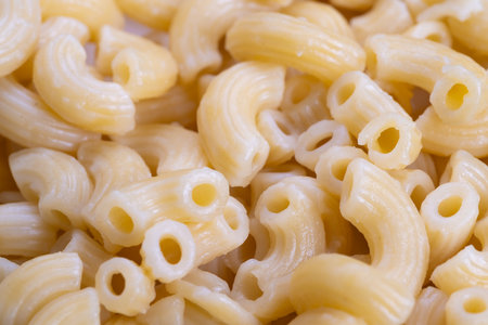 Tasty pasta presentation, Creamy cooked spirals in inviting and comforting tones, Delicious creamy elbow macaroni carefully presented in warmly inviting bowl environmentの写真素材