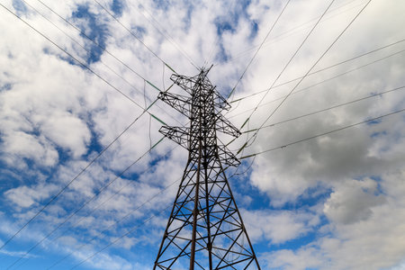 A striking power tower silhouette stands tall against a backdrop of a dramatic, cloudy sky