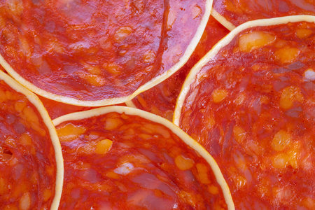 Juicy sausage rounds radiating warm tones and spice, glossy surface with visible seasonings, homey...