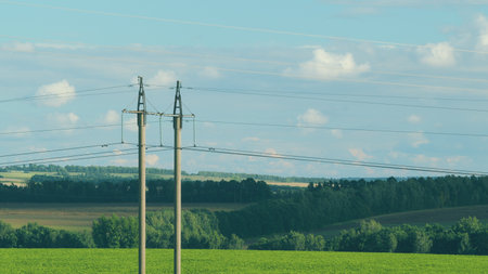 Power Lines Over a Scenic Landscape with a Beautiful Blue Sky and Fluffy Clouds
