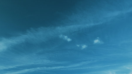 A Beautiful Tranquil Blue Sky with Gentle Wispy Clouds Floating Gracefully Above