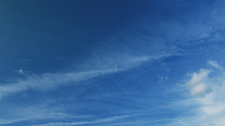 A Beautiful Blue Sky adorned with Fluffy Clouds and Contrails from Jet Aircraft above