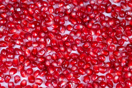 Highresolution image showcasing fresh red pomegranate seeds for packaging. Macro photograph of shiny...