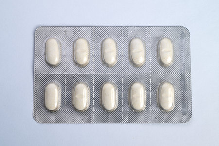 Packaging concept showcasing uniform oblong tablets in foil packs. Product presentation emphasizing...