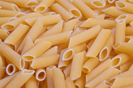 Closeup bulk penne conveying pantry supply and kitchen readiness, industrial quantity appearance...