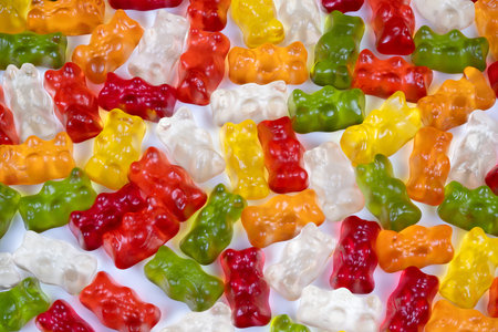 Nostalgic multicolored gummy bears evoke childhood memory with glossy translucent reds, greens and...