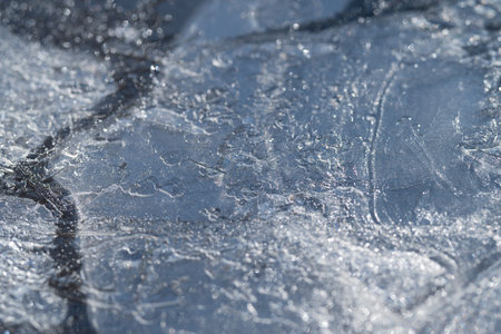 Ice surface intricacies. Frozen ice with delicate cracking. Cracked frozen surface shows frost and...