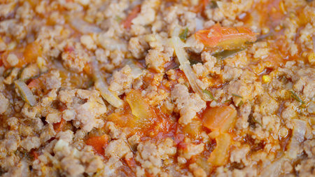 Warm aromatic blend of ground beef with fresh garden produce slowcooking. Slowly simmering savory combination of beef and vegetables in cozy country kitchen settingの写真素材