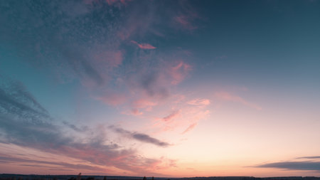 Dusk sky scene, Serene twilight sky featuring pastel colors and distant city silhouette, Calm sunset...