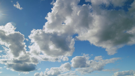 Experience the beauty of a cloudy sky with various shapes against a vivid blue backdrop