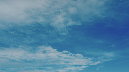 A Beautiful and Serene Blue Sky Adorned with Fluffy White Clouds During Bright Daylightの写真素材