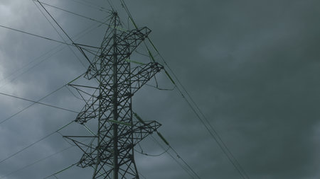 A Dramatic High Voltage Power Line Silhouetted Against the Foreboding Dark Sky Background