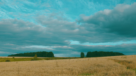 A Serene and Picturesque Countryside Landscape Beneath Dramatic and Captivating Cloudsの写真素材