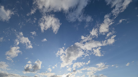 A Beautiful Sky Filled with Fluffy Clouds and Rays of Sunlight Bringing Warmth and Joy