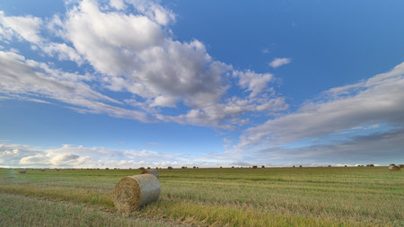 A breathtaking scenic landscape featuring hay bales beautifully situated under a bright blue sky