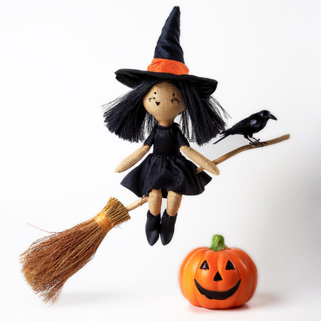 Halloween doll with broom and pumpkin isolated on a white background.の素材