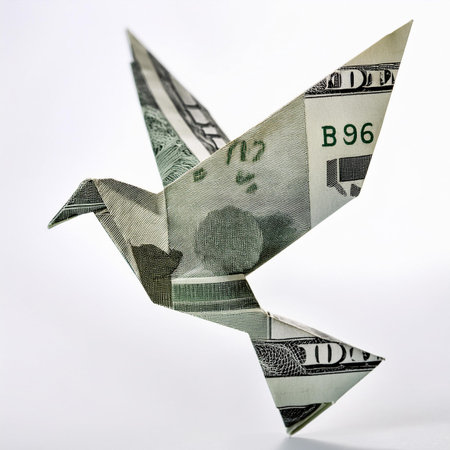 Origami bird made of dollars on a white background. Isolatedの素材