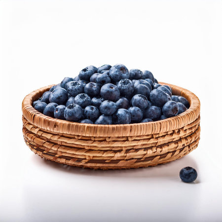 Fresh blueberries in a wicker basket on a white background.の素材
