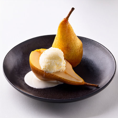 Fresh pears with ice cream on a black plate on a white backgroundの素材