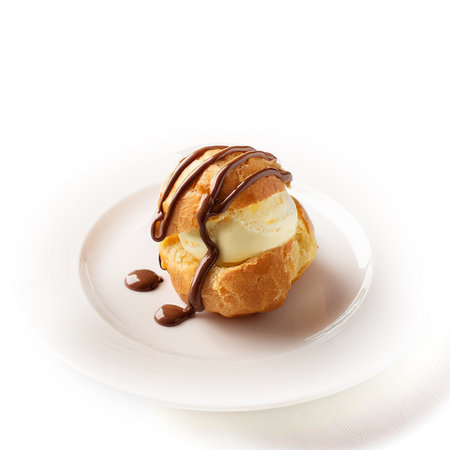 Cream puff with ice cream on a plate isolated on white backgroundの素材