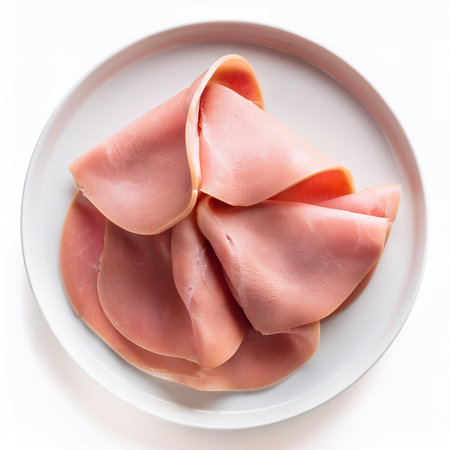 Slices of ham on white plate isolated on white background.の写真素材