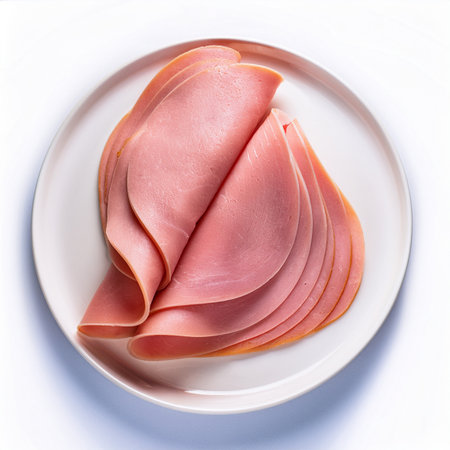 Slices of ham on a plate. Isolated on a white background.の写真素材