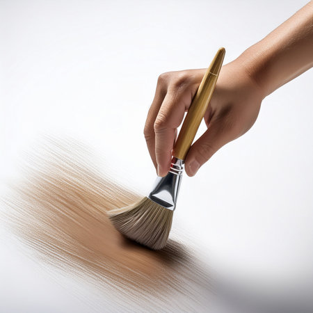Close up of a woman's hand holding a paint brush on white backgroundの素材