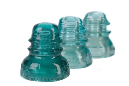 Three antique glass telephone insulators. Shot against white background.の写真素材