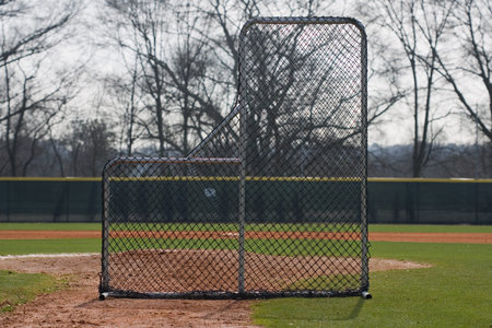 Pitching screen set on infield of baseball field