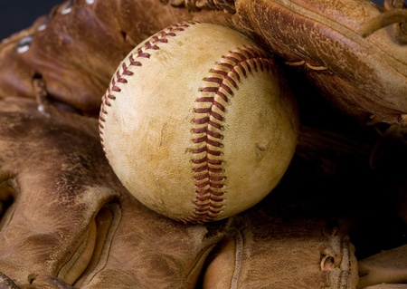 Worn baseball laying in an old gloveの写真素材