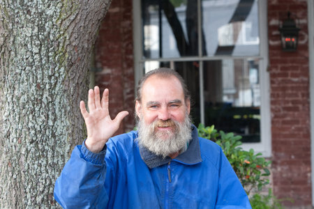Homeless man waving while outdoors during the daytime  