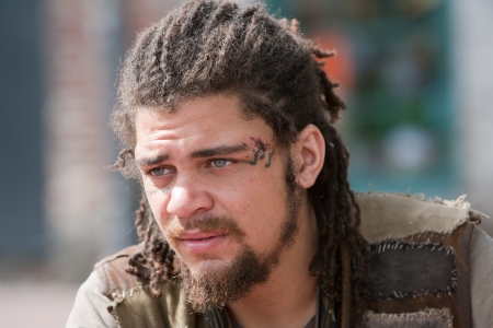Portrait of young rebellious man with dreadlocks and tattoosの写真素材