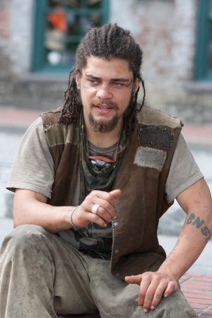 Rebel with dreadlocks and tattoos sitting outsideの写真素材