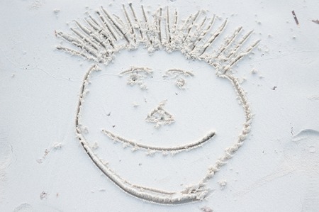 Funny smiley face drawn on white sand of Maldivesの写真素材