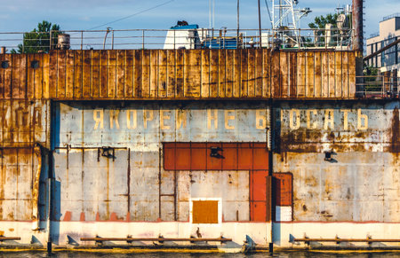 Rusty equipment in river docks with Russian lettering - No anchoring