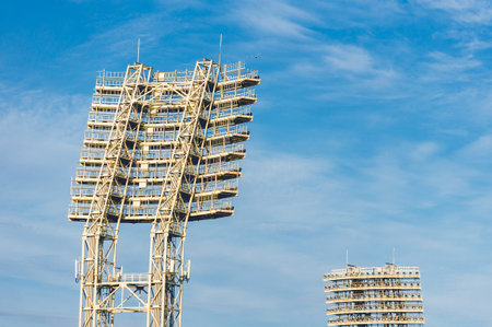 Stadium lights towers in the daytime against blue sky