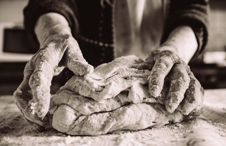 old italian grandma making pasta in the kitchen sepia effectの写真素材