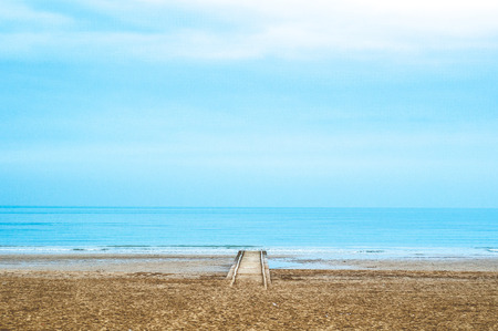old wooden pier on the sea in cold winter cloudy dayの写真素材