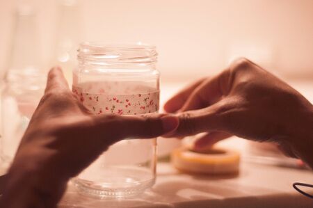 young woman attaching adhesive to glassの写真素材