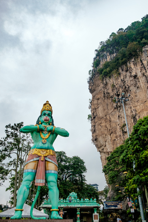 huge blue statue of hindu god hanuman at entrance of batu caves during cloudy day in kuala lumpur malaysiaの写真素材