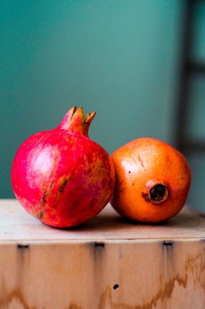 closeup of fresh ripe red pomegranates on wood table with natural lightの写真素材