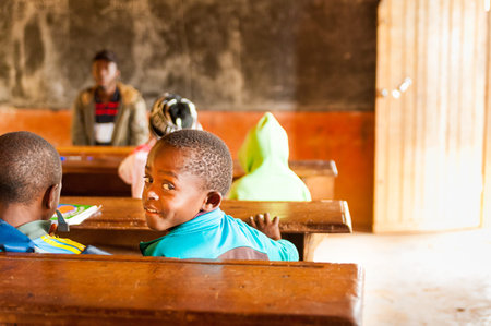 Bafoussam, Cameroon - 06 august 2018:  smiling african child looking in camera during lesson in...