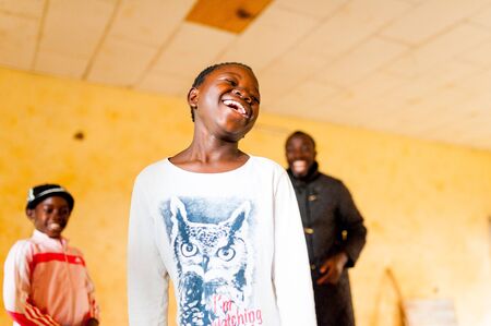Bafoussam, Cameroon - 06 august 2018: young smiling african girls and boys playing and having fun indoor poor village school during summerのeditorial素材