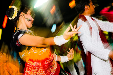 Vadodara, India - 20 october 2018: men and women in traditional indian dresses dance garba during...