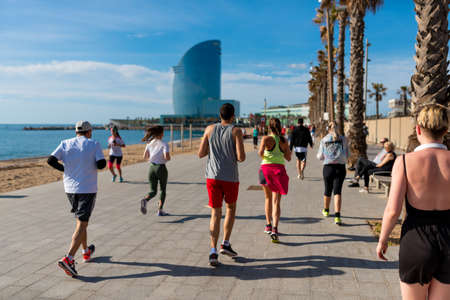 Barcelona, Spain - 2 may 2020: people do sport in barceloneta beach wearing protection face mask against coronavirus, after the first phase of the desescalada and the end of the confinement and social distancingのeditorial素材